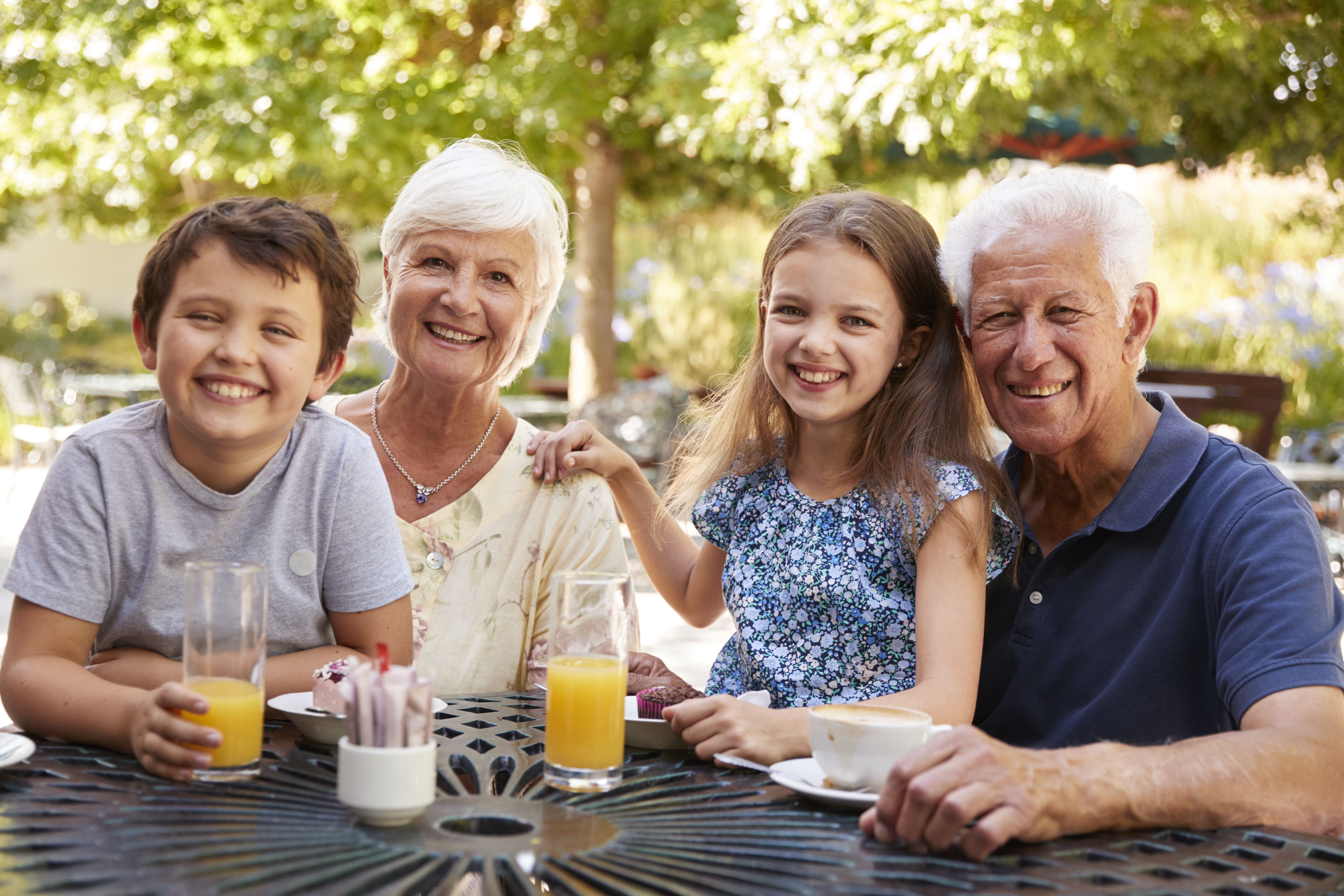 Grandparents And Grandchildren Enjoying Snack At Outdoor Caf